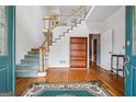 Inviting foyer featuring hardwood floors, a staircase, and a decorative rug at 2200 Gleneagle Nw Ct, Conyers, GA 30012