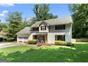 Traditional-style home with mature trees, a two-car garage and a welcoming entrance, offering classic appeal at 2612 New Haven Dr, Jonesboro, GA 30236