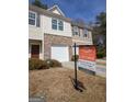A townhouse featuring a 'for sale' sign, showcasing the front exterior with a garage at 6342 Kinsland Ct, Lithonia, GA 30058