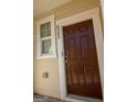 A close-up of a modern brown front door with a small window to the side at 6342 Kinsland Ct, Lithonia, GA 30058