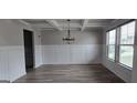 Bright dining room featuring wainscoting, modern chandelier and luxury vinyl plank flooring at 336 Traditions Ln # 147, Hampton, GA 30228