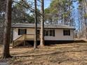 Exterior showcasing traditional siding and a cozy front porch with new stairs, creating a welcoming entrance framed by nature at 2211 Newborn Rd, Rutledge, GA 30663
