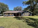 Inviting home features a spacious front yard and mature trees providing ample shade at 3280 Gum Creek Rd, Oxford, GA 30054