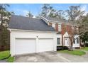 Side view of a two story brick home with attached two car garage and well maintained lawn at 5105 Cascade Hills Cir, Atlanta, GA 30331