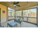 Cozy screened porch with seating area, fan, and a view of the surrounding trees at 5997 Wildcreek Rd, Sugar Hill, GA 30518