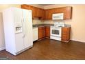 Functional kitchen featuring white appliances, brown wood cabinets and vinyl floors at 209 East Wilson St # 25, Villa Rica, GA 30180