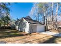 Rear view of a light gray home with an attached garage and a manicured lawn at 403 Sandown Dr, Peachtree City, GA 30269