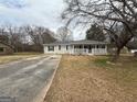 Quaint single-story home with a covered front porch and a long driveway at 245 Carole Dr, Oxford, GA 30054