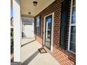 Covered front porch with brick siding, a 'Welcome' doormat, and dark window shutters at 7491 Hilltop Way, Atlanta, GA 30349