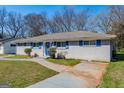 Charming single-story home with a painted brick exterior, blue shutters and a well-manicured lawn at 1393 Vesta Ave, Atlanta, GA 30344