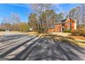 A charming two-story red brick home with a classic design, set on a large lot with mature trees at 423 Holly Grove Church Rd, Peachtree City, GA 30269
