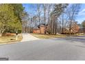 Traditional two-story red brick home with a driveway, nestled among mature trees at 423 Holly Grove Church Rd, Peachtree City, GA 30269
