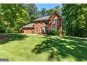 Charming two-story brick home with well-maintained lawn and landscaping surrounded by lush greenery at 423 Holly Grove Church Rd, Peachtree City, GA 30269