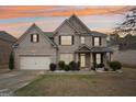 Two-story brick home with attached garage, manicured landscaping, and covered front porch at 3225 Alhambra Cir, Hampton, GA 30228