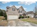 Lovely two-story brick home with attached garage, manicured landscaping, and covered front porch at 3225 Alhambra Cir, Hampton, GA 30228