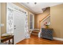 Welcoming foyer with hardwood floors, staircase, and decorative cabinet, creating a warm entrance at 9800 Ivey Ridge Cir, Jonesboro, GA 30238