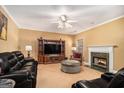 Cozy living room featuring a fireplace, plush seating, and a ceiling fan for ultimate comfort at 9800 Ivey Ridge Cir, Jonesboro, GA 30238