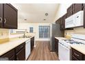 Galley-style kitchen with stainless steel appliances, white countertops, and dark wood cabinets with an eat in area at 3821 Rex Mill Sq, Rex, GA 30273