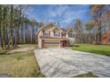 Charming two-story home with a tan exterior, a brick foundation, and a well-maintained lawn at 440 Cottonpatch Rd, Lawrenceville, GA 30046