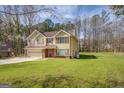 Charming two-story home with a tan exterior, a brick foundation, and a well-maintained lawn at 440 Cottonpatch Rd, Lawrenceville, GA 30046