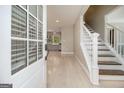 Inviting foyer showcasing wood floors, a staircase with white railings, and a view into the adjacent kitchen at 650 Moseley Rd, Stockbridge, GA 30281