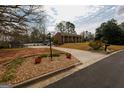Well-maintained front yard featuring lush landscaping, mature trees, and a classic brick home at 3798 Cumberland Way, Lithonia, GA 30038