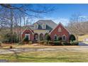 Beautiful brick home with well-maintained landscaping, mature trees, and a circular driveway at 820 Huiet Dr, Mcdonough, GA 30252