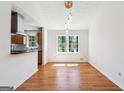 Elegant dining room boasts hardwood floors, modern lighting, and abundant natural light at 4967 Post Road Pass, Stone Mountain, GA 30088