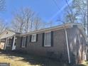 Side view of a brick home featuring symmetrical window placement and manicured landscaping at 4572 Sahara Sw Dr, Atlanta, GA 30331