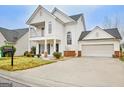 Beautiful two-story home featuring a welcoming front porch, and driveway leading to a two-car garage at 306 Turtle Pointe Dr, Carrollton, GA 30116