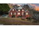 Charming two-story brick home with manicured landscaping, a retaining wall, and welcoming front porch at 10119 Azalea Dr, Covington, GA 30014