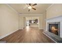 Bright living room showcasing a fireplace, ceiling fan, and open layout with access to the kitchen at 2389 Aukerman Trce # 79, Hampton, GA 30228