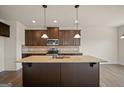 Gourmet kitchen with a large island, granite countertops, and stainless steel appliances at 2376 Aukerman Trce, Hampton, GA 30228