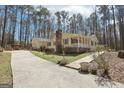 Spacious home features a long driveway, an attached garage, and a well-maintained lawn with decorative landscaping at 179 Green Valley Rd, Fayetteville, GA 30214