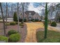 Brick home featuring lush landscaping and a winding driveway with mature trees at 90 Oak Walk, Villa Rica, GA 30180