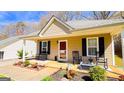 Inviting front porch with rocking chairs, fresh landscaping, and covered entrance at 136 Glynn Addy Dr, Stockbridge, GA 30281