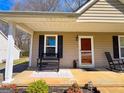 Covered front porch featuring seating, landscaping, and a welcoming entrance at 136 Glynn Addy Dr, Stockbridge, GA 30281