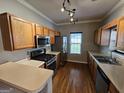 Well-lit kitchen features stainless steel appliances, wooden cabinets and hardwood floors at 741 S Fairfield Dr, Peachtree City, GA 30269