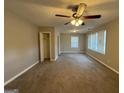 Large carpeted bedroom features a ceiling fan, closet and three windows at 1643 Columbia Dr, Decatur, GA 30032