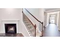 Inviting entryway with hardwood floors, a staircase with wooden railing and a fireplace, creating a warm ambiance at 2455 Westlington Cir, Cumming, GA 30040