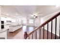 Open-concept living space with hardwood floors, a ceiling fan and a view of the modern kitchen at 2455 Westlington Cir, Cumming, GA 30040