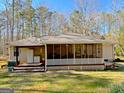 View of a screened-in porch, adjacent to an exterior refrigerator and offering a relaxed space for outdoor enjoyment at 127 Circle H Rd, Sharpsburg, GA 30277