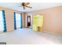 Bright, carpeted living room with a ceiling fan and cheerful yellow shelving at 260 Brookwood Ln, Fayetteville, GA 30215