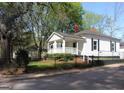 Beautifully maintained single-story home with a cozy front porch, fenced yard, and mature trees at 1 Maple St, Porterdale, GA 30014