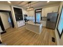 Modern kitchen with stainless steel appliances, granite countertops, a center island and wood look flooring at 1 Maple St, Porterdale, GA 30014