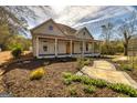 Charming single-story house featuring an arched garden trellis, a cozy front porch, and manicured landscaping at 721 Wedowee St, Bowdon, GA 30108