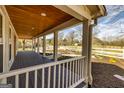 Inviting covered porch with a wood ceiling, white railings, and serene views of the landscaped front yard at 721 Wedowee St, Bowdon, GA 30108