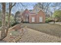 Traditional brick home with a covered porch and a nicely sloped front yard at 300 The Enclave, Peachtree City, GA 30269