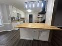 Well-lit kitchen featuring an island with wooden countertop and sleek black appliances at 127 Brookwood Estates Trl, Stockbridge, GA 30281