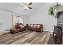 Spacious living room featuring wood-look floors, a fireplace and comfortable brown seating at 152 Summerfield Dr, Mcdonough, GA 30253
